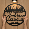 Personalized round lake house sign with mountains and pine trees in black steel