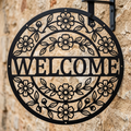 Round floral welcome metal sign with flower and leaf wreath in black steel